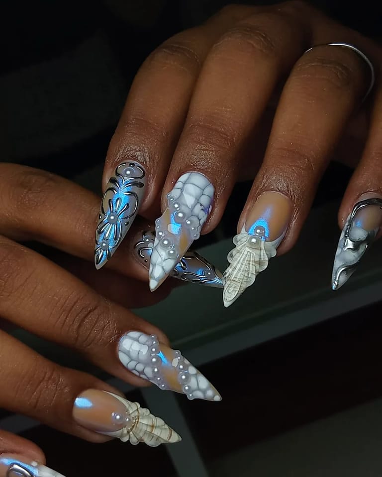 Nail art de invierno en azul con copos de nieve y dijes